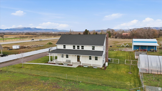 1009 High Creek Road Cove, UT 84320 - Photo 7 of 79 View of front of property featuring covered porch, a fenced backyard, a rural view, a chimney, and a mountain view