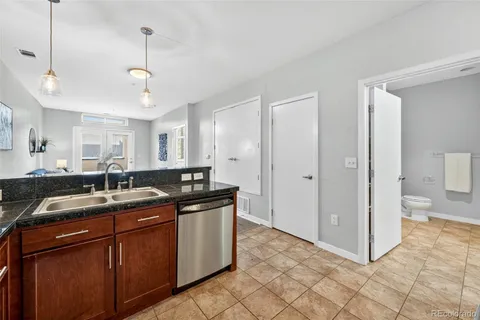 a kitchen with stainless steel appliances granite countertop a sink and a refrigerator