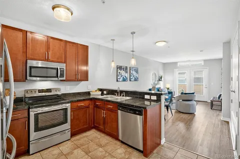 a kitchen with granite countertop a stove top oven sink and cabinets
