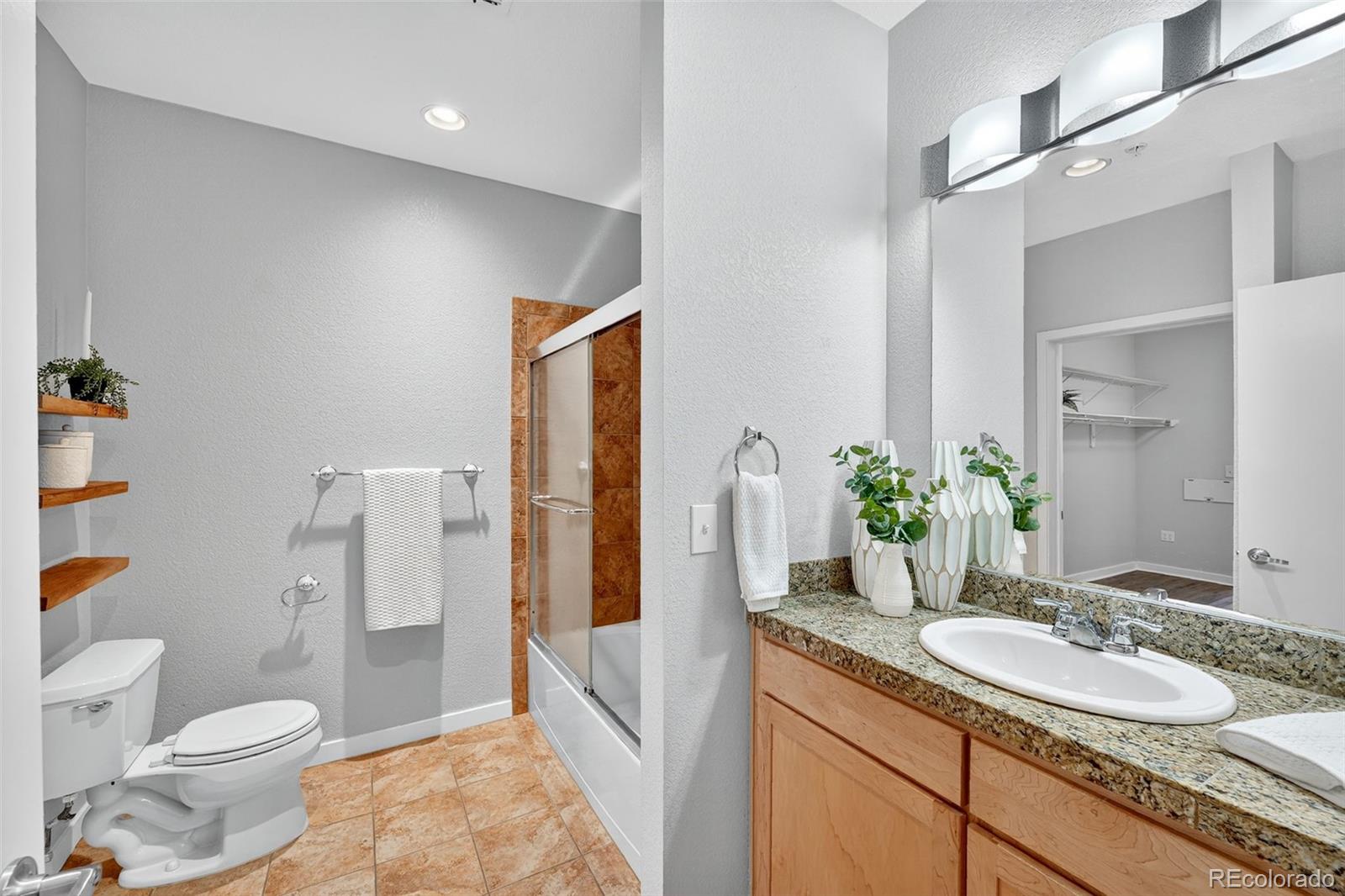 3101 Blake Street, Unit 209 Denver, CO 80205 - Photo 17 of 33 a bathroom with a granite countertop sink and a mirror