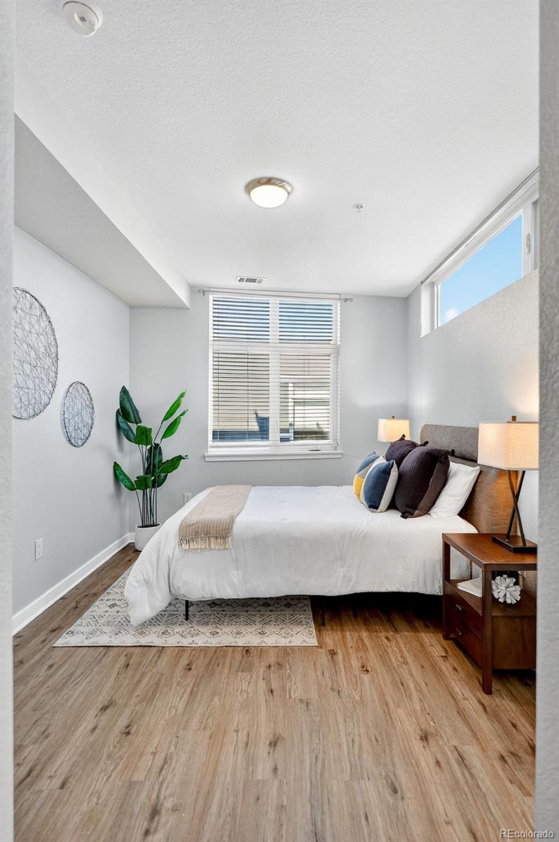 3101 Blake Street, Unit 209 Denver, CO 80205 - Photo 20 of 33 a bedroom with a bed window and wooden floor