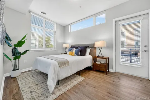 a bedroom with a large bed and a potted plant