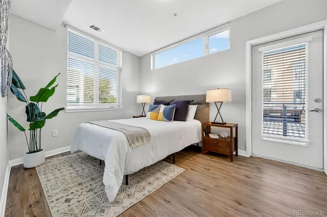 a bedroom with a large bed and a potted plant