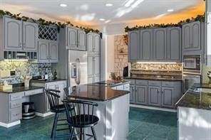335 Red Oak Court, Unit 335 Monroeville, PA 15146 - Photo 7 of 50 a kitchen with kitchen island granite countertop a table chairs stove and cabinets