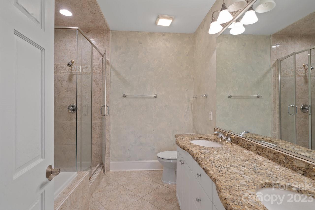 4409 Mickleton Road Charlotte, NC 28226 - Photo 21 of 31 a bathroom with a granite countertop sink a toilet and shower