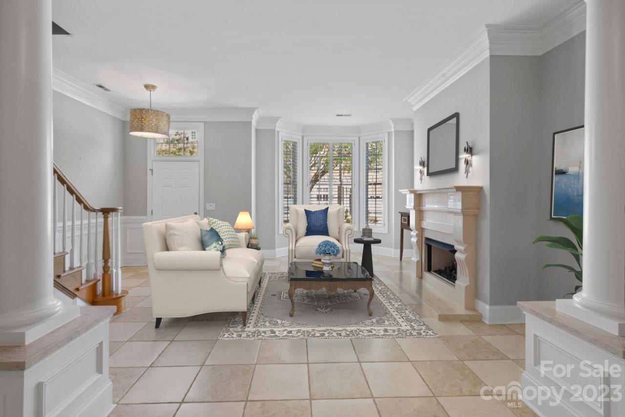 4409 Mickleton Road Charlotte, NC 28226 - Photo 9 of 31 a living room with furniture a fireplace and a chandelier