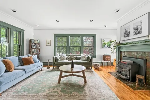 a living room with furniture a fireplace and a floor to ceiling window