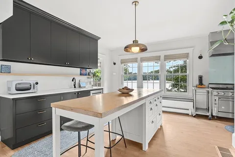 a kitchen with stainless steel appliances granite countertop a sink a stove and a wooden floors