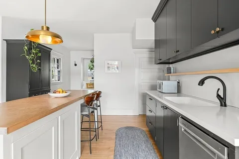 a kitchen with stainless steel appliances granite countertop a sink a stove and a wooden floors