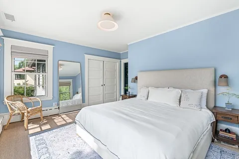 a bedroom with a bed and a large window