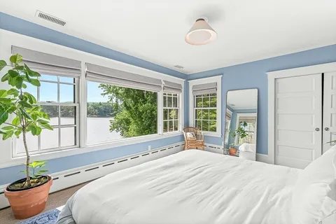 a bedroom with a bed and a large window