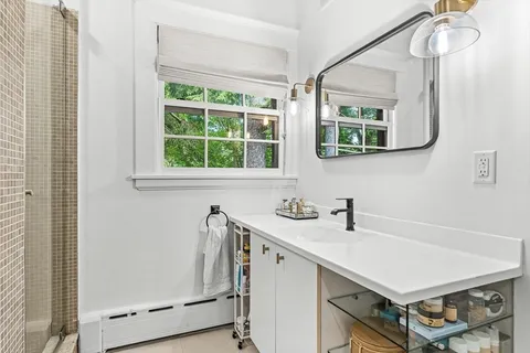 a bathroom with a sink a mirror and a window