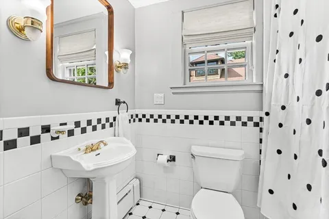 a bathroom with a sink a toilet and a mirror