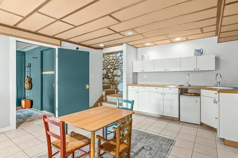a kitchen that has a lot of white cabinets and stainless steel appliances
