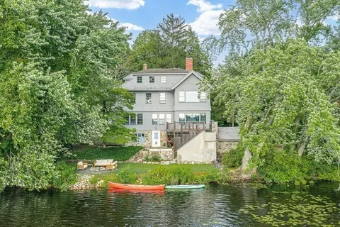 a view of a house with a yard and a pond