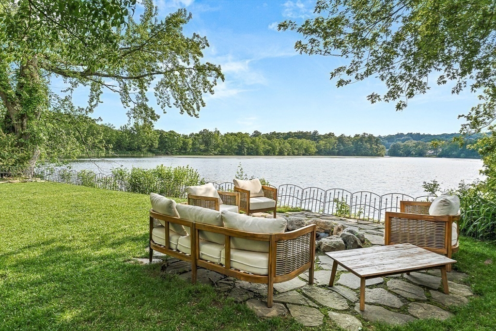9 Lakeview Terrace Winchester, MA 01890 - Photo 4 of 42 a view of a lake with couches and table and chairs under an umbrella