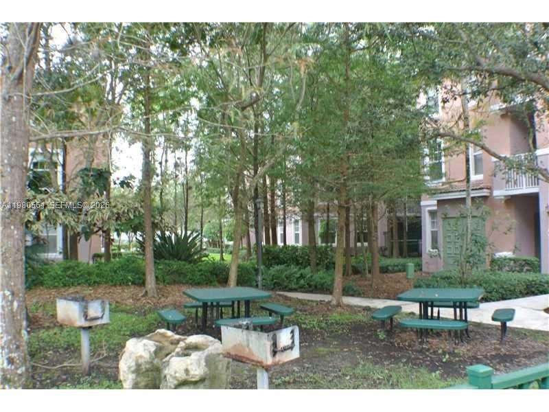 6660 West Sample Road, Unit 6660 Coral Springs, FL 33067 - Photo 25 of 30 a view of a table and chairs in the garden