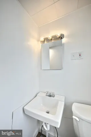 a bathroom with a sink a toilet and mirror