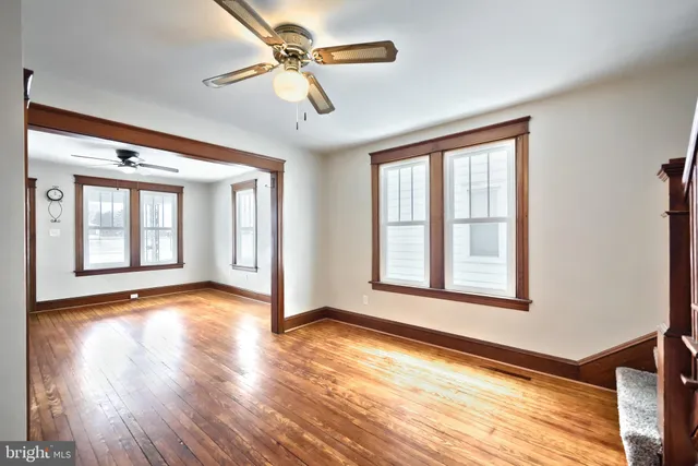 a view of an empty room with a window and wooden floor