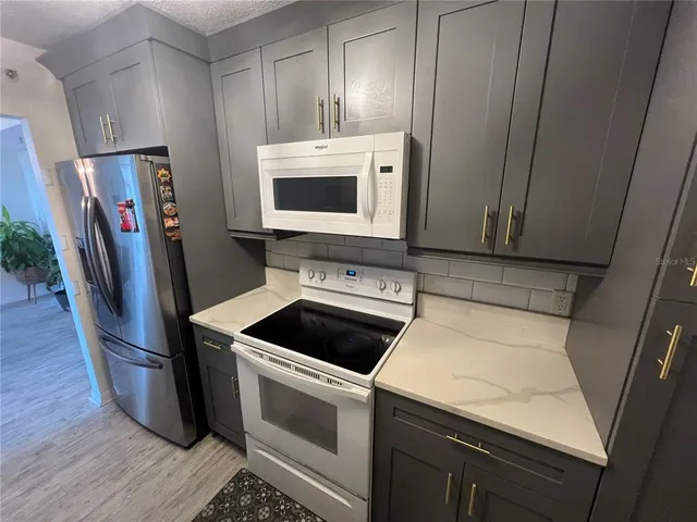 a kitchen with stainless steel appliances a stove microwave and sink