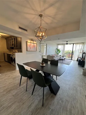a view of a dining room with furniture a chandelier and wooden floor