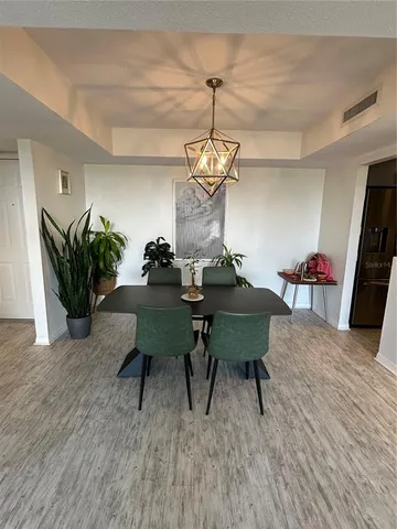 a dining room with furniture a chandelier and wooden floor