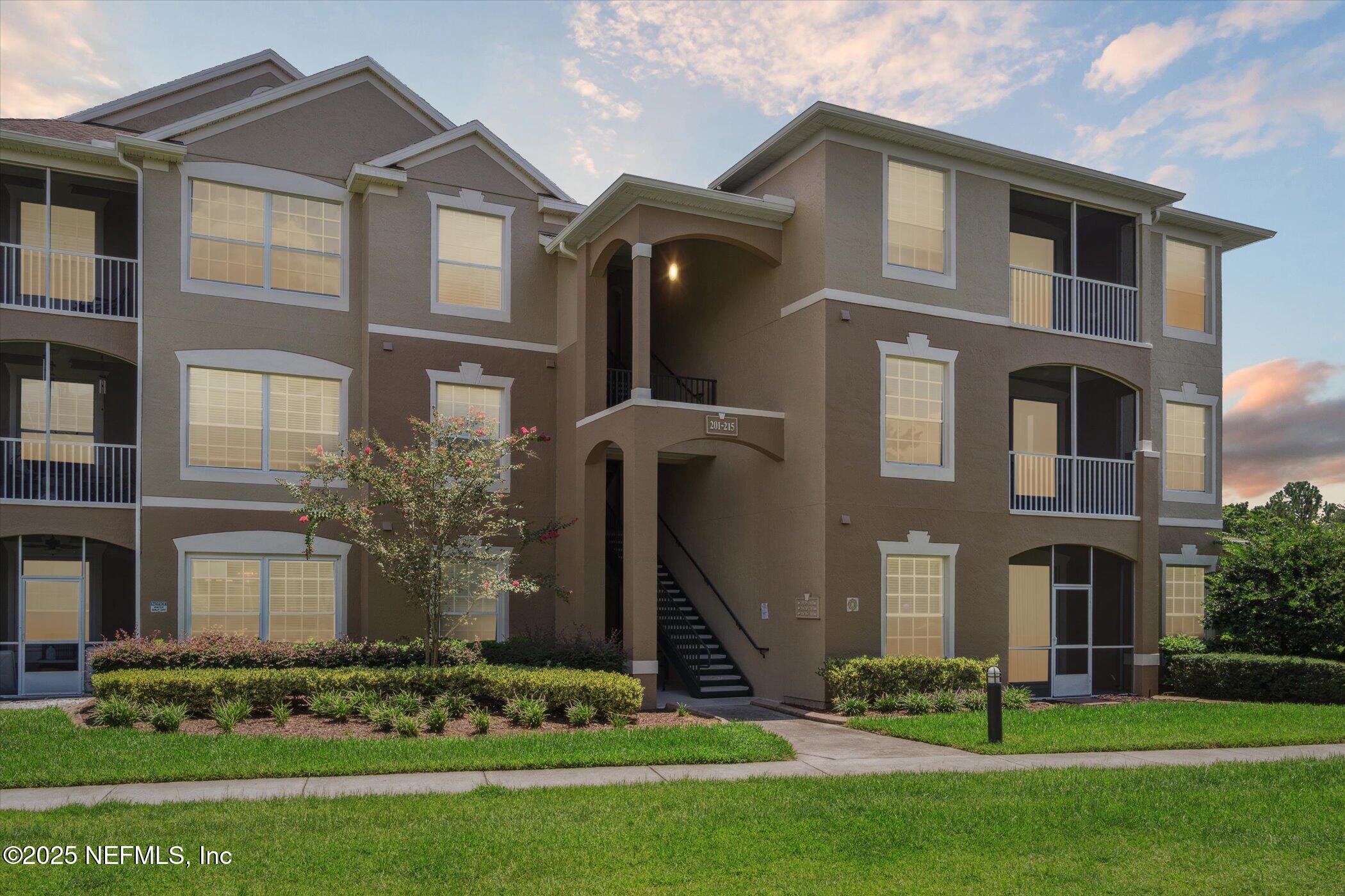 7990 Baymeadows Road East, Unit 201 Jacksonville, FL 32256 - Photo 2 of 43 a front view of a house with garden