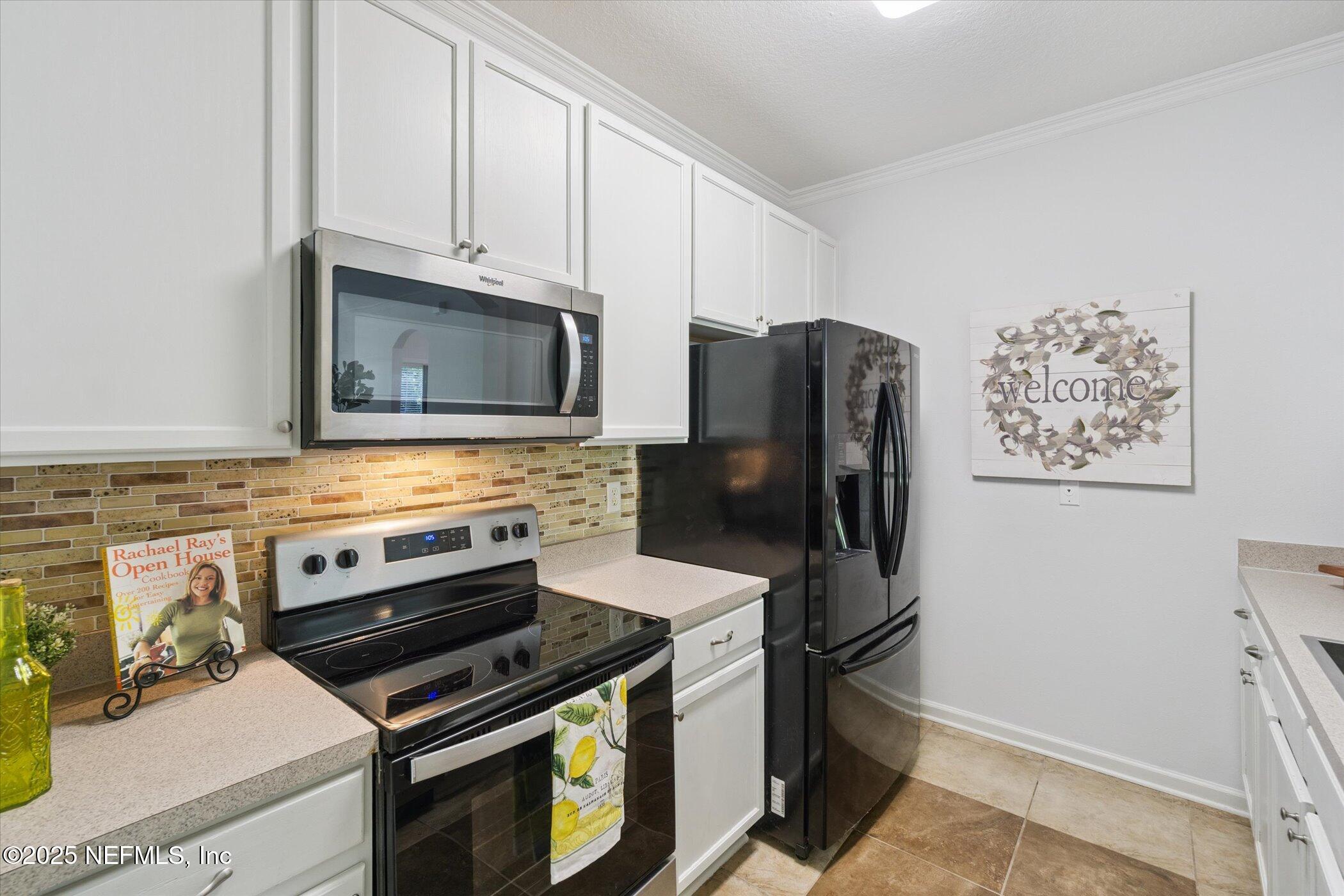 7990 Baymeadows Road East, Unit 201 Jacksonville, FL 32256 - Photo 8 of 43 a kitchen with stainless steel appliances a refrigerator stove and microwave