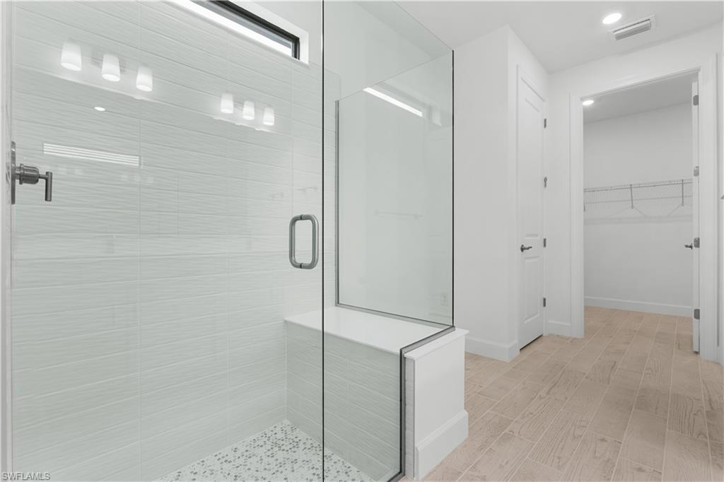 2104 Freemont Way Naples, FL 34119 - Photo 11 of 27 view of primary bathroom leading into spacious closet