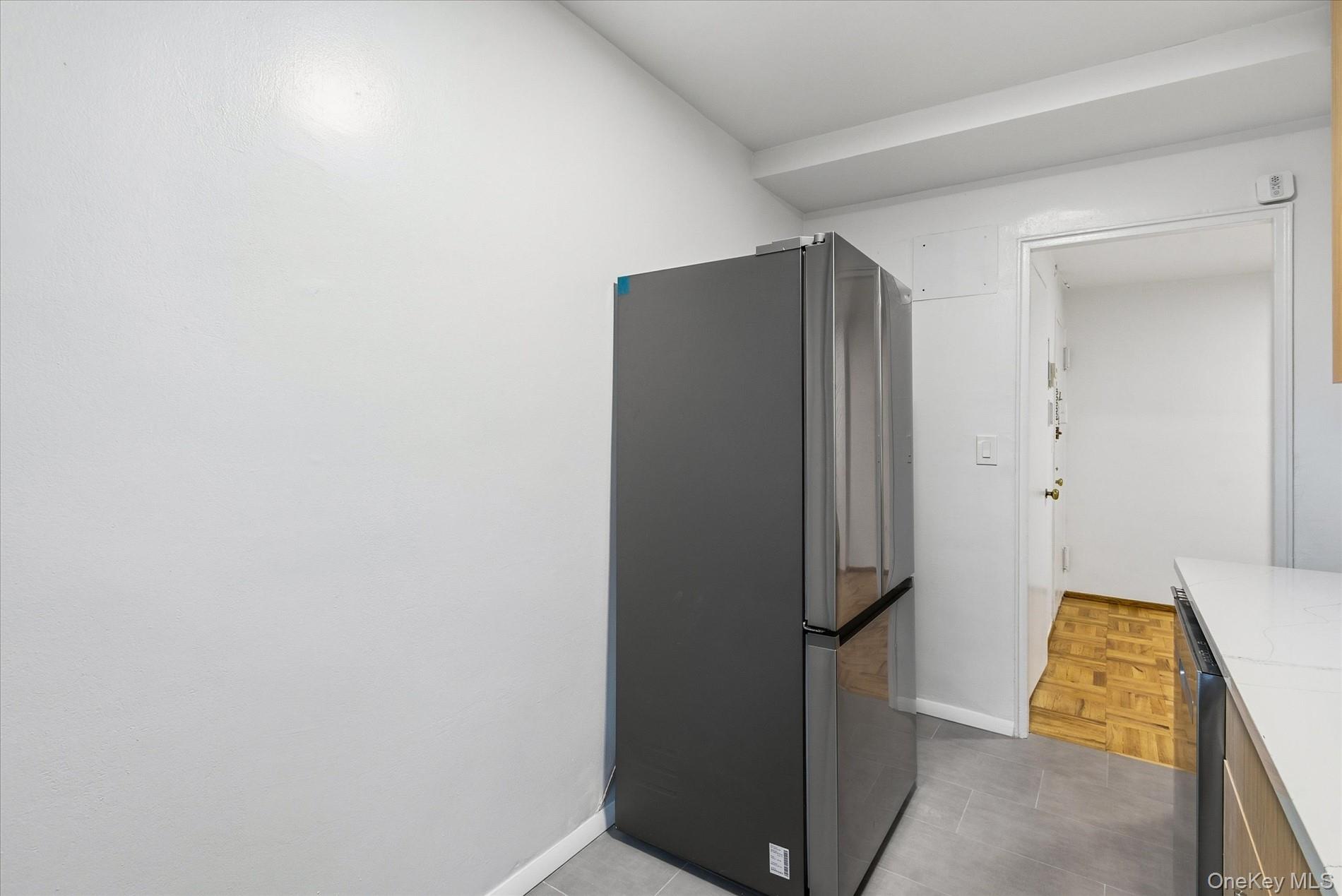21-85 34th Avenue, Unit 2D Queens, NY 11106 - Photo 8 of 17 Kitchen with stainless steel appliances and light tile patterned floors