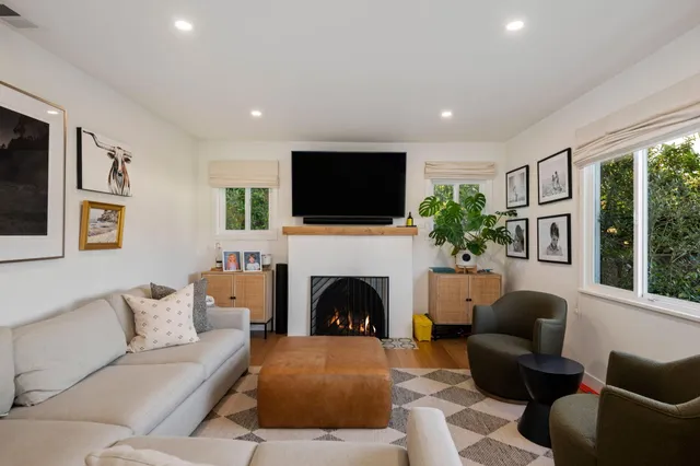 a living room with furniture a flat screen tv and a fireplace