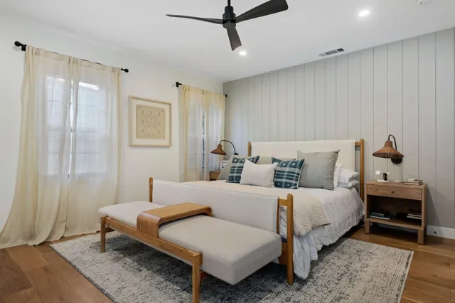 a bedroom with a bed wooden floor and window