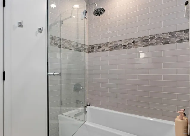 a bathroom with a shower and a bath tub