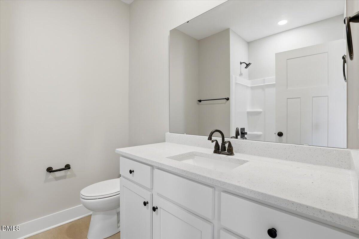 358 Natchez Trace Fuquay-Varina, NC 27526 - Photo 18 of 26 a bathroom with a sink a toilet and a mirror
