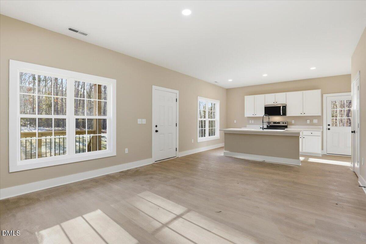 358 Natchez Trace Fuquay-Varina, NC 27526 - Photo 4 of 26 a view of an empty room with kitchen and window