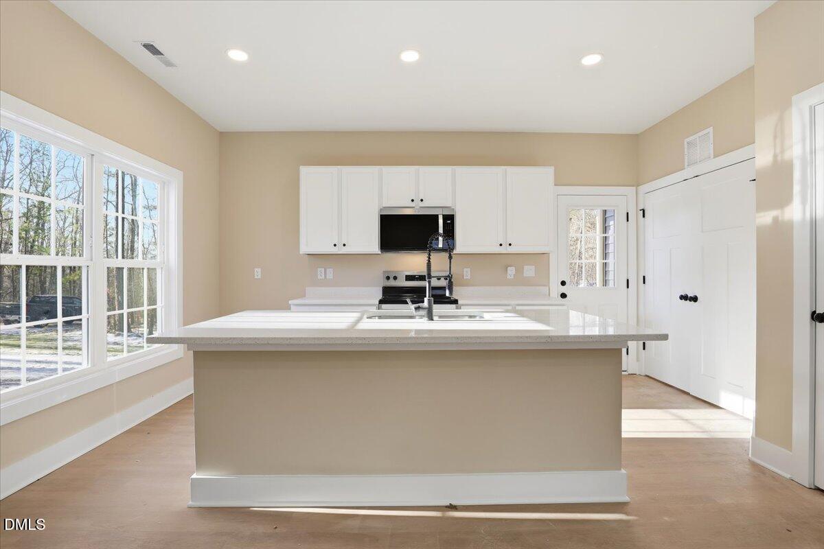 358 Natchez Trace Fuquay-Varina, NC 27526 - Photo 5 of 26 a kitchen with kitchen island stainless steel appliances a sink stove and refrigerator