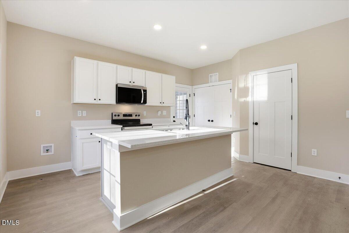 358 Natchez Trace Fuquay-Varina, NC 27526 - Photo 6 of 26 a view of kitchen with stainless steel appliances granite countertop a stove a sink and a refrigerator