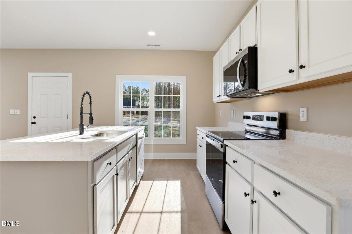 358 Natchez Trace Fuquay-Varina, NC 27526 - Photo 8 of 26 a kitchen with stainless steel appliances granite countertop a sink and a stove