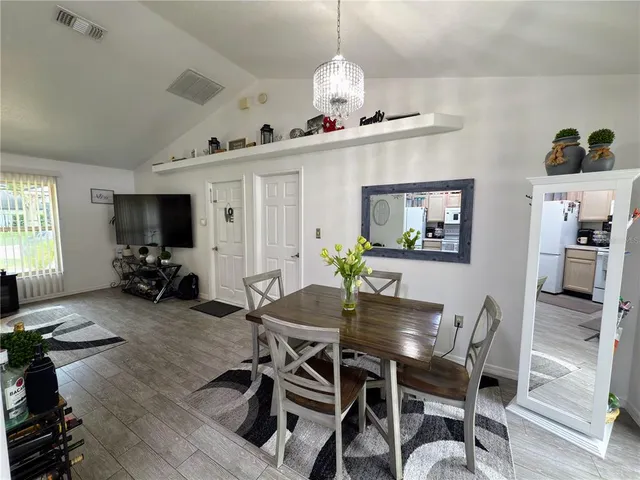 a view of a dining room with furniture wooden floor and a chandelier