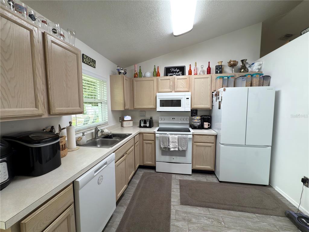 408 Raymond Street Minneola, FL 34715 - Photo 13 of 40 a kitchen with a white stove top oven and white refrigerator