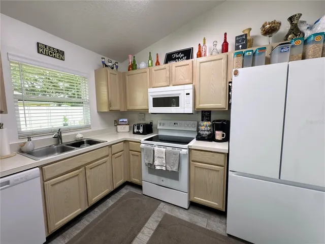 a kitchen with a sink a refrigerator and cabinets