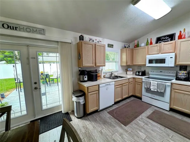 a kitchen with granite countertop a stove top oven a sink and cabinets