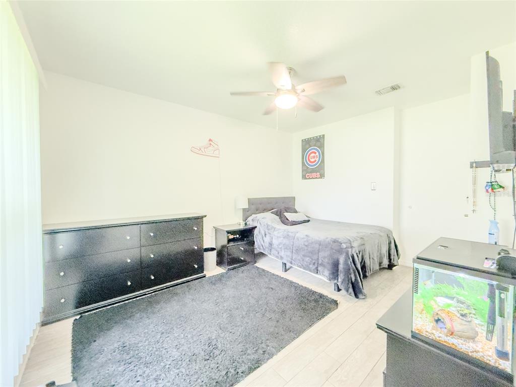 408 Raymond Street Minneola, FL 34715 - Photo 18 of 40 a spacious bedroom with a bed and a window