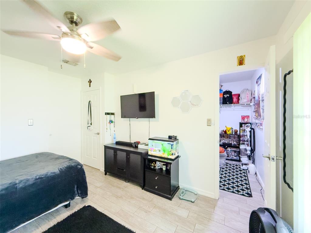 408 Raymond Street Minneola, FL 34715 - Photo 19 of 40 a bedroom with a bed and a flat screen tv