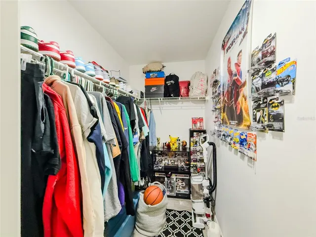 a view of walk in closet with clothes and shoes