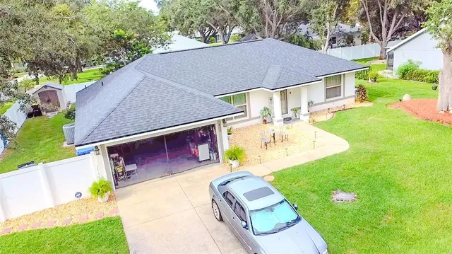 a aerial view of a house with table and chairs under an umbrella