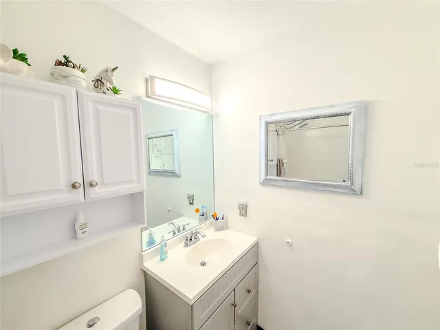 a bathroom with a sink toilet and mirror