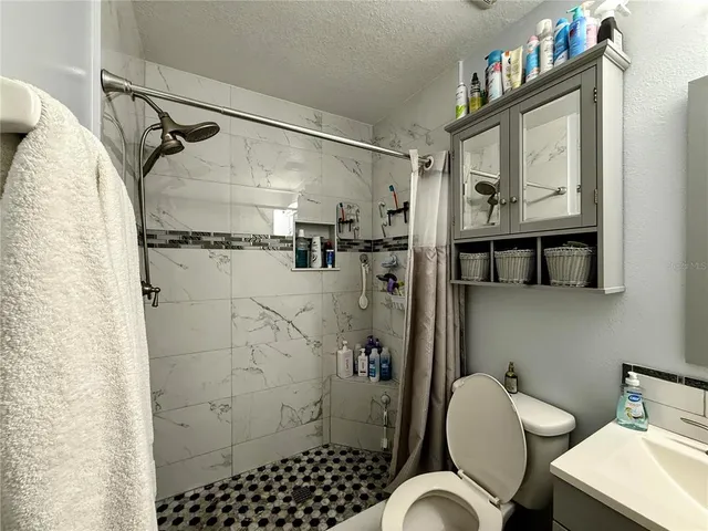 a bathroom with a sink toilet and shower