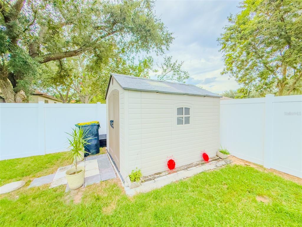 408 Raymond Street Minneola, FL 34715 - Photo 33 of 40 a white house with a yard and sitting area