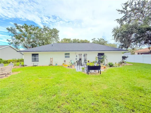 a view of a house with a backyard and a patio